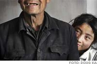 13-åriga Wu Xia från Liang Jia Dian i Shanxiprovinsen, tittar fram bakom sin farfar Gao Sitaos axel.