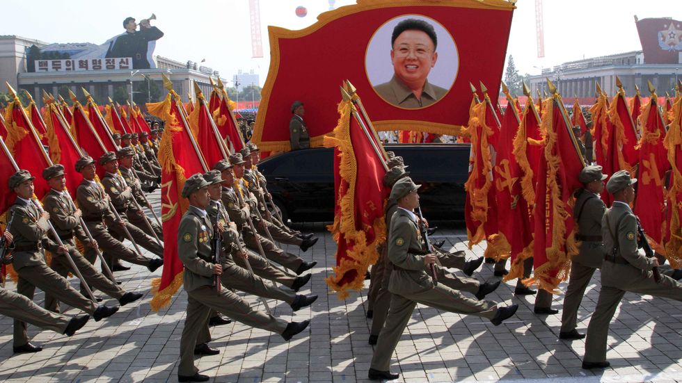 Nordkoreanska trupper marscherar förbi ett porträtt av Kim Jong II.