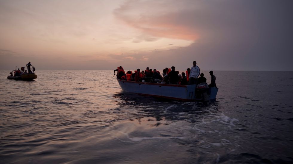 Migranter på en överbelastad träbåt i Medelhavet, fotograferade 2019.
