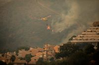 En helikopter vattenbombar branden i Estepona, Spanien.