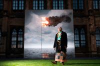 Uili Lousi, miljöaktivist, konstnär och representant för Tonga på klimatmötet i Glasgow, framför ett konstverk som visar hur Tongas flagga brinner i havet.