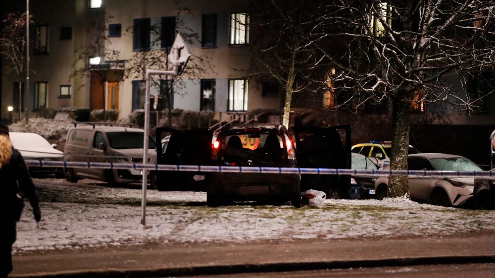 En sönderskjuten bil på platsen där två personer sköts i Rågsved.