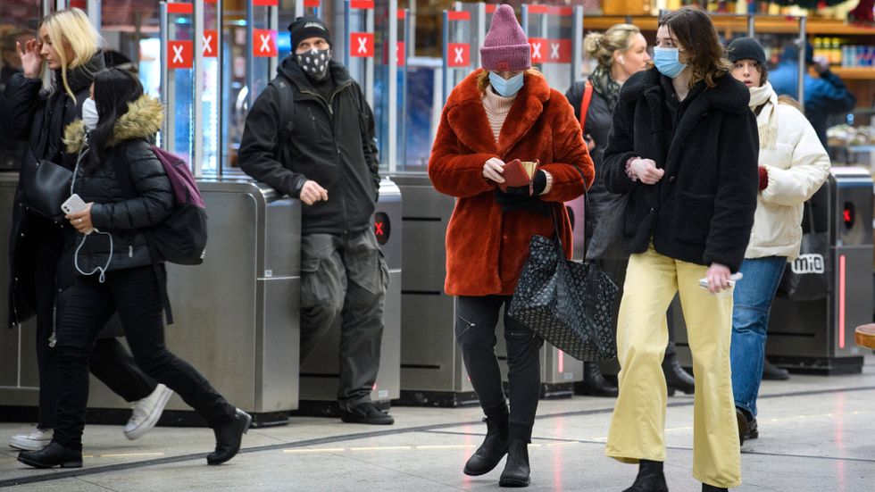 Resenärer i tunnelbanan vid Gullmarsplan i Stockholm bär munskydd. Arkivbild.
