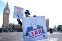 En demonstrant håller upp ett plakat utanför parlamentet i London, där tidigare premiärministern Boris Johnson fick svara på anklagelser om att han vilselett parlamentet angående sin kännedom om brott mot pandemilagarna. Arkivbild.