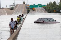 USA i Augusti 2017. Efter orkanen Harvey vadar evakuerade nedför en översvämmad del av vägen Interstate 610. 