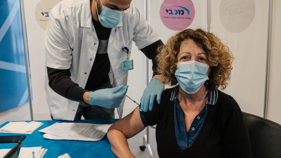 En kvinna i Jerusalem, Israel, får en dos av Pfizers vaccin den 24 december. 