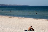 En strand i australiska Adelaide i delstaden South Australia vid en värmebölja i januari. Arkivbild.