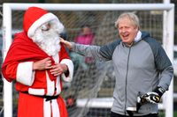 Storbritanniens premiärminister Boris Johnson hälsar på jultomten innan en fotbollsmatch som han besökte under ett stopp på sin valturné i Cheadle Hulme i lördags.
