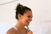 En kvinnlig student skriver på franska på vita tavlan på Stockholms universitet.