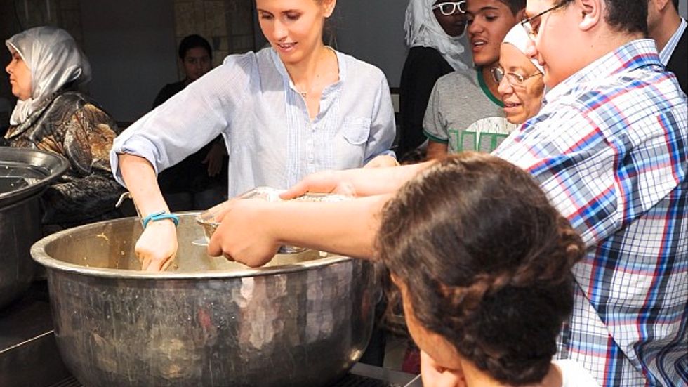 Syriens första dam, Asma Assad, serverar mat i ett soppkök i Damaskus 2013.