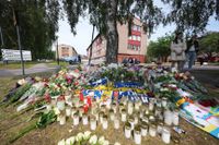 Blommor och ljus vid platsen där en polis sköts till döds i Biskopsgården, två dagar efter mordet.