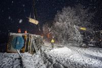En lastbil som vält i halkan norr om Röke utanför Hässleholm bärgas i ymnigt snöfall på tisdagskvällen.