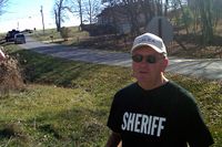 Sheriffen  David Barber talar med reportarar utanför huset där de fyra försvunnit.