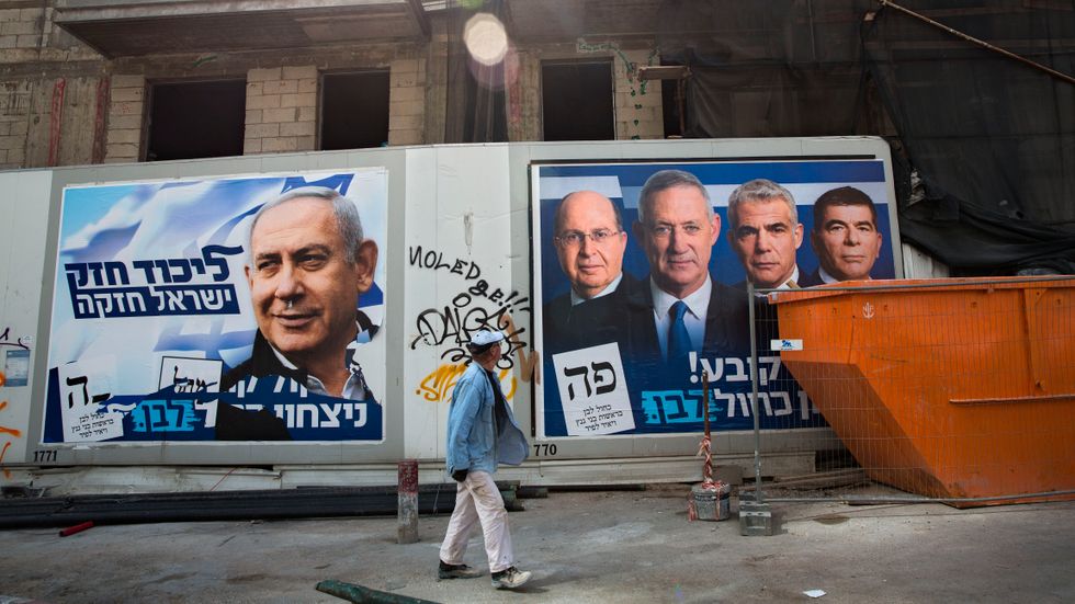 Före detta militärchefen Benny Gantz och nybildade Blåvita alliansen utmanar premiärministern Benjamin Netanyahu. Här går en man förbi kampanjskyltar i Tel Aviv under valdagen.