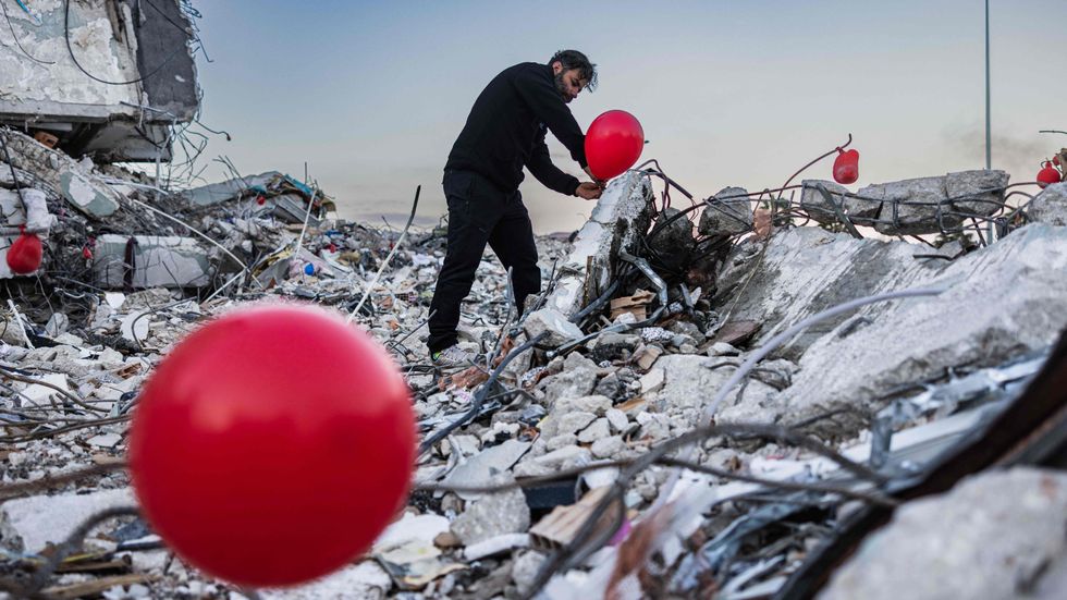 Ogun Sever Okur sätter ut röda ballonger på byggnader som rasat i den svårt skalvdrabbade staden Antakya. Ballongerna ser han som en hyllning till barn som har omkommit i skalven.