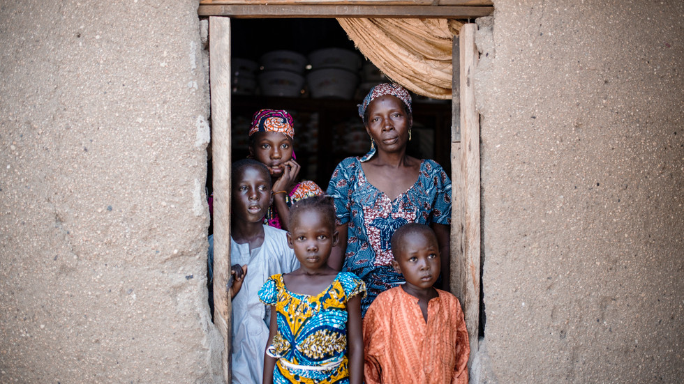 Fadimatou och hennes syskon med sin ”fostermamma”, Fadi, som stod och sålde kol längs vägen när barnen gråtande kom och bad om vatten för två år sedan.