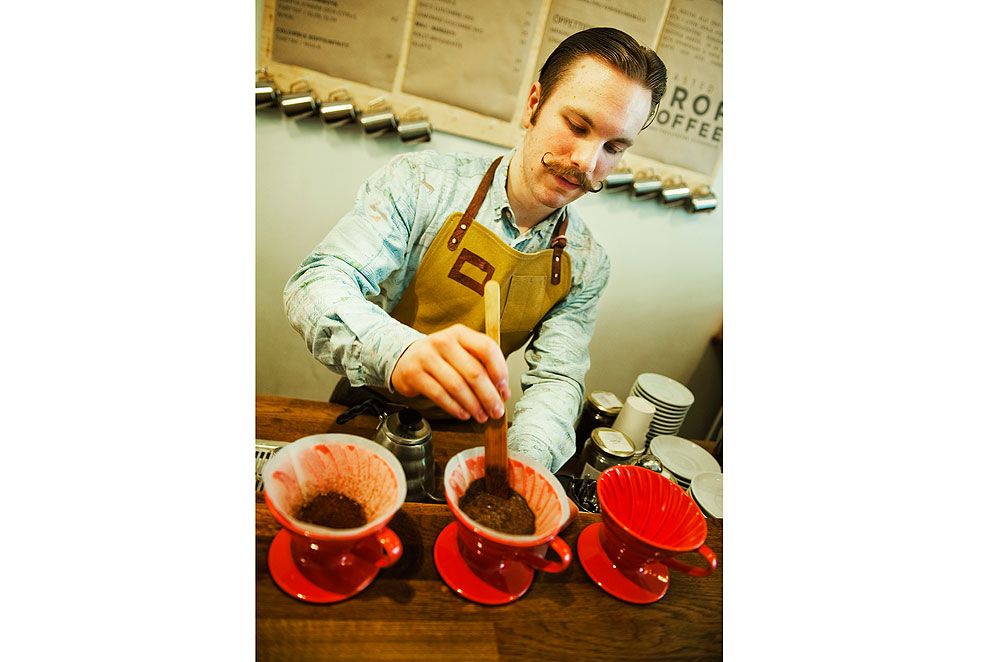 Simon Westerlund brygger färskmalet kaffe i filterbehållare av porslin.