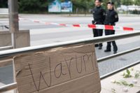 En skylt med texten "Varför?" har placerats ut i närheten av köpcentrumet Olympia, där nio personer sköts till döds i attacken.