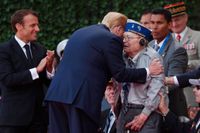 USA:s president Donald Trump omfamnar en av de veteraner som var med under D-dagen och som deltog i 75-årsdagens ceremonier. Frankrikes president Emmanuel Macron står bredvid och applåderar.