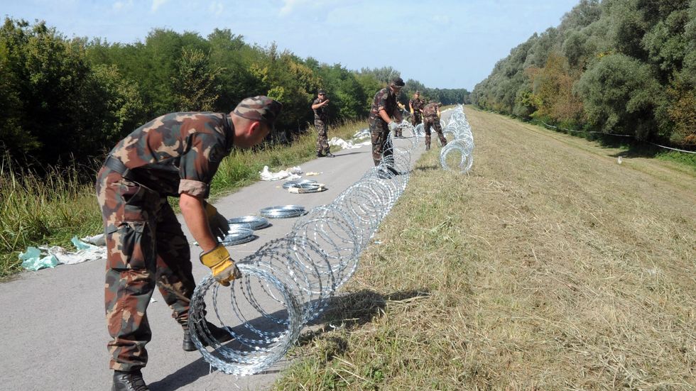 Ungerska soldater spärrar av gränsen mot Kroatien med rakbladsvass taggtråd.