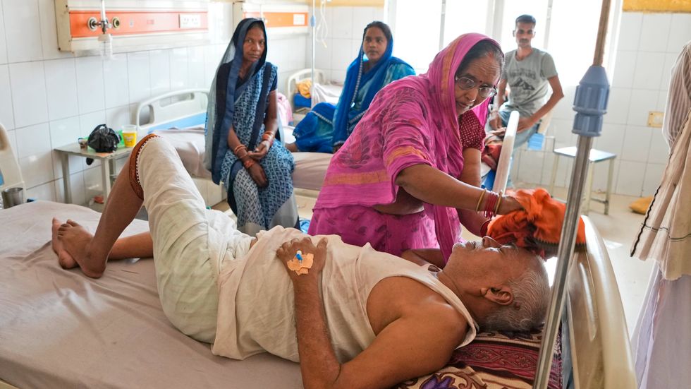 Shiela Mishra försöker kyla ner sin bror genom att badda honom med en blöt trasa. Bilden är tagen på ett sjukhus i Ballia i Uttar Pradesh i Indien under en värmebölja i juni förra året.