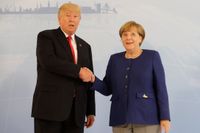 Donald Trump och Angela Merkel skakar hand.