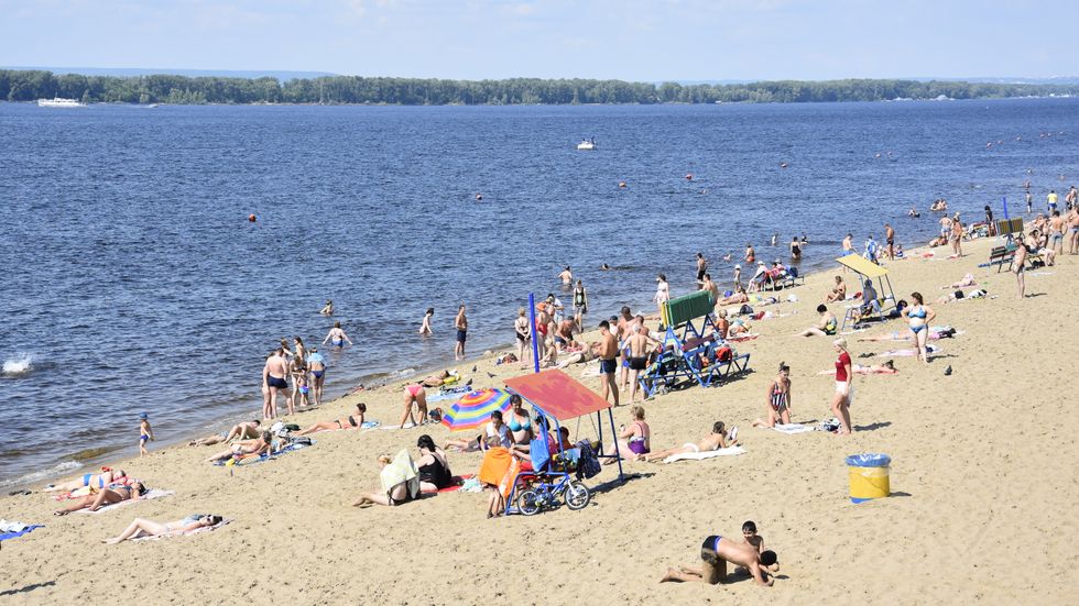 Både unga och gamla badar i Volga vid sandstränderna mitt inne i miljonstaden Samara i södra Ryssland.