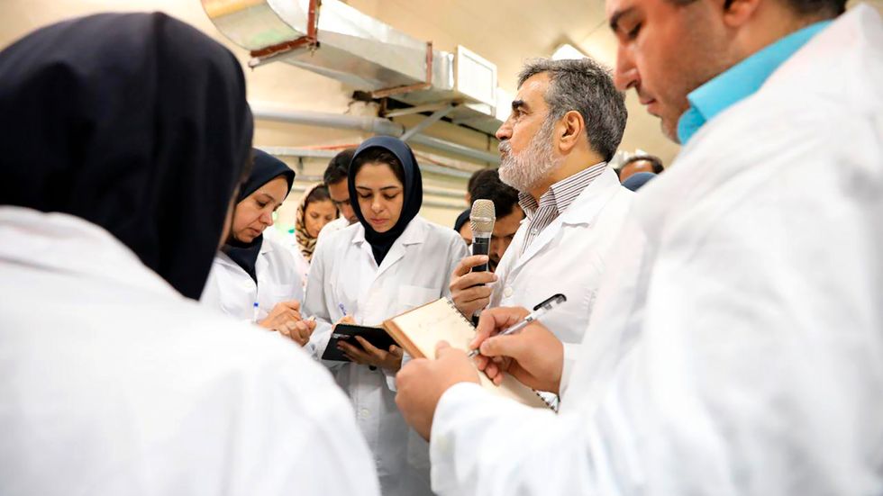 Irans atomenergiorganisations talesperson Behroz Kamalvandi (mitten) besöker en atomenergianläggning söder om Teheran. Bilden tillhandahålls av den statliga organisationen.