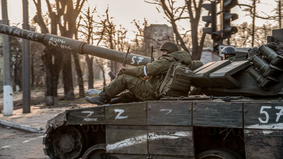 Ryska soldater vilar sig på en z-märkt stridsvagn i ukrainska Mairupol.